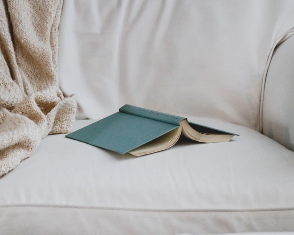 an open book sitting on top of a white couch