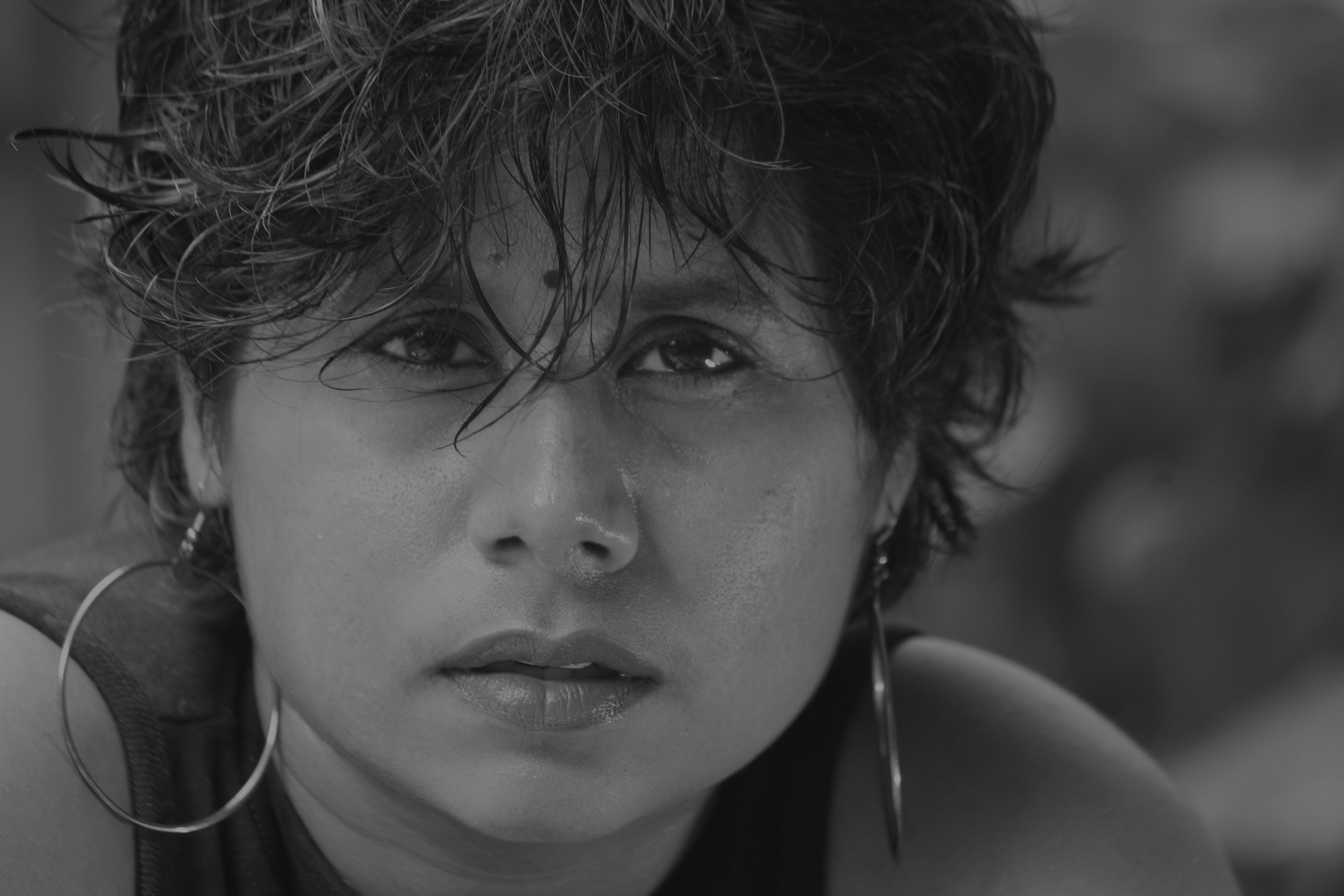 a black and white photo of a woman with large hoop earrings