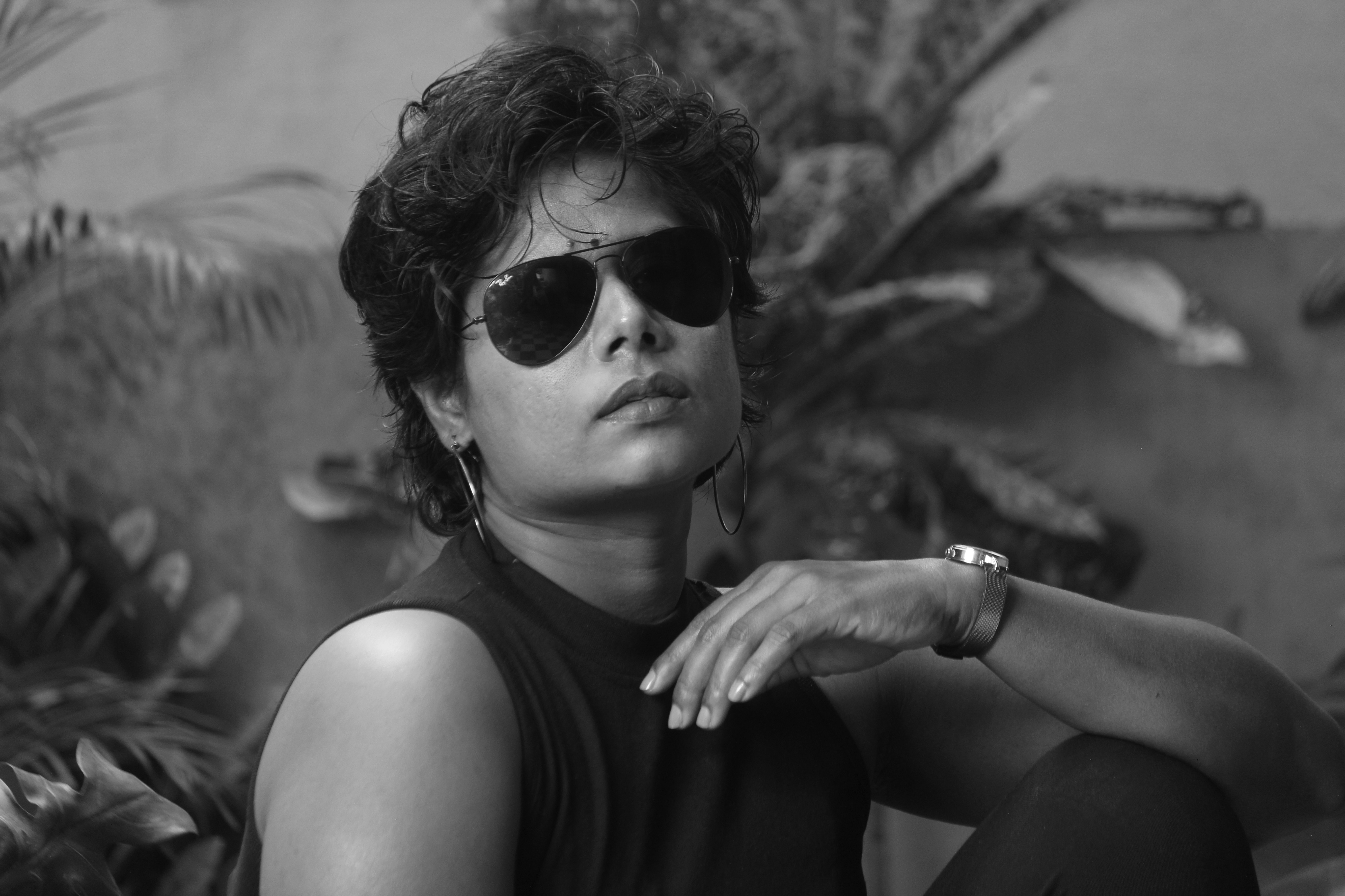 a woman wearing sunglasses sitting on a bench