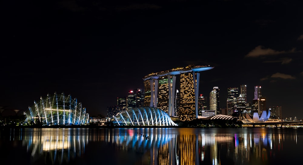 a city skyline at night with lights reflecting in the water