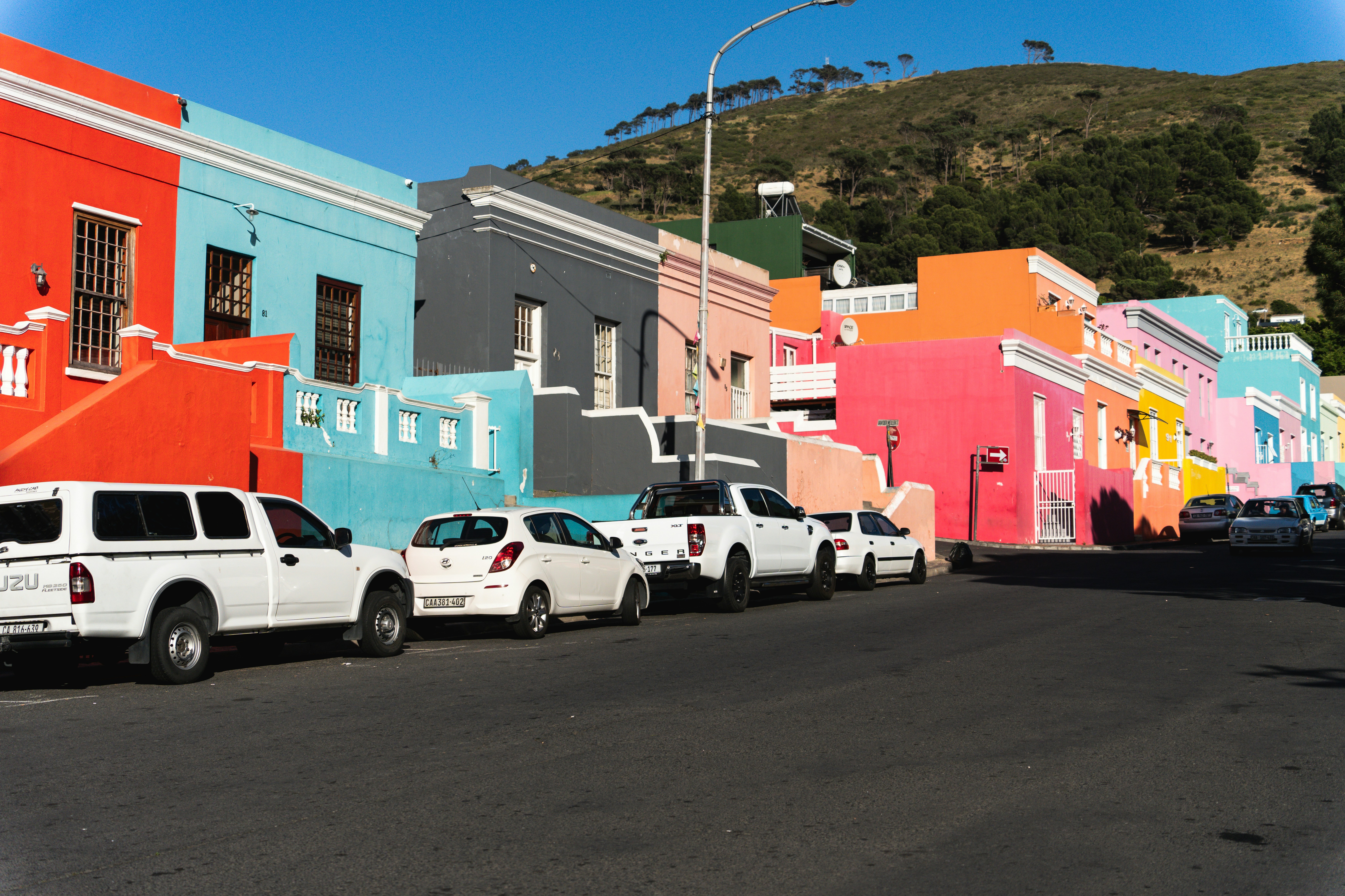 a row of parked cars in front of a multi - colored building
