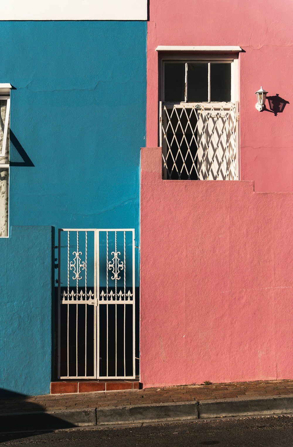 a pink and blue building with a white window