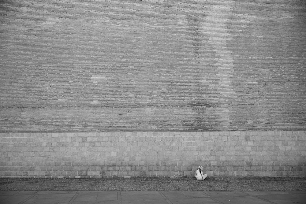 a black and white photo of a person sitting on a bench