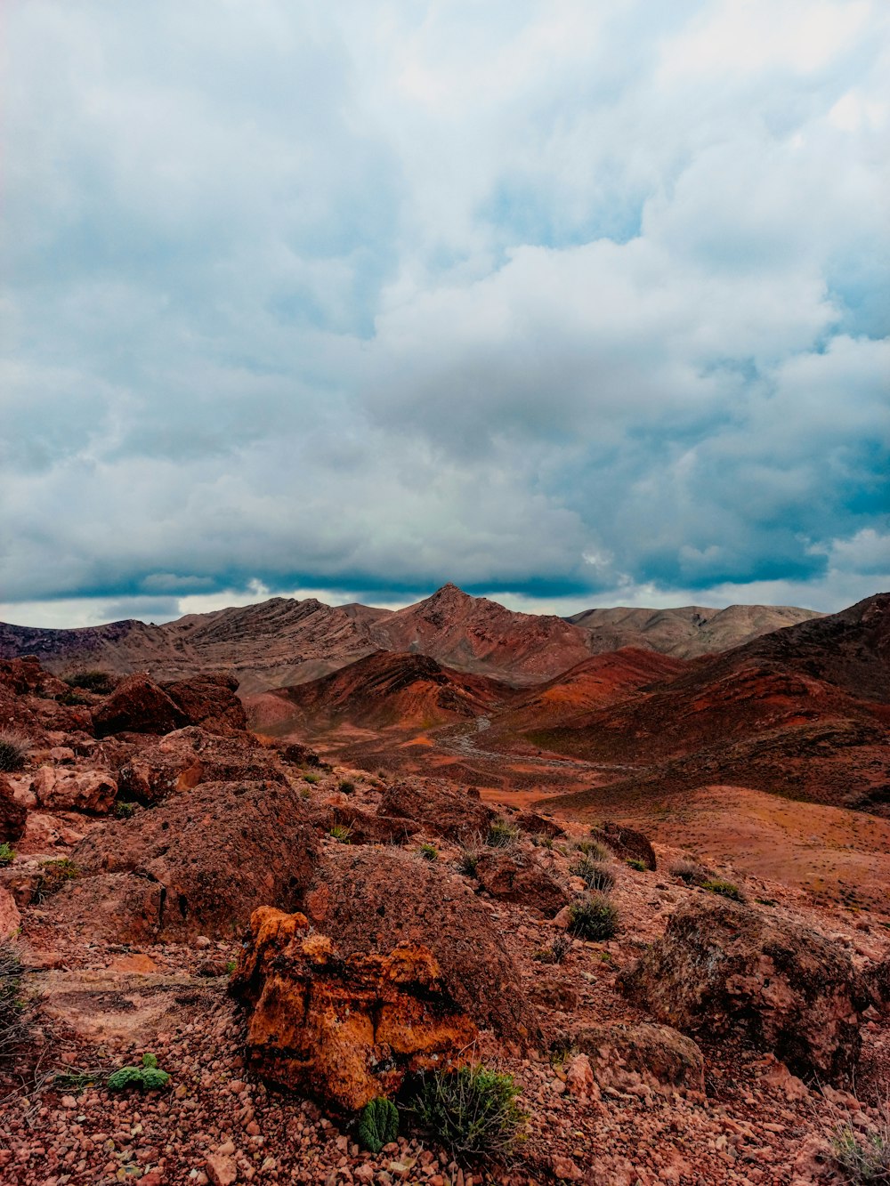 a view of a mountain range with a cloudy sky in the background