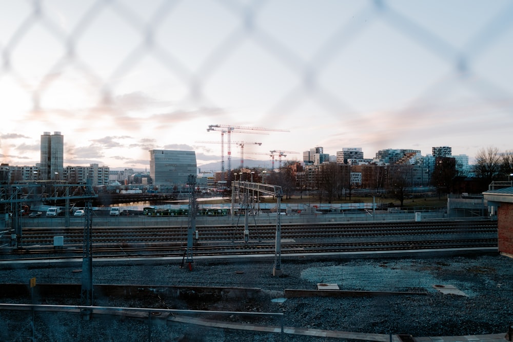 a view of a city through a chain link fence