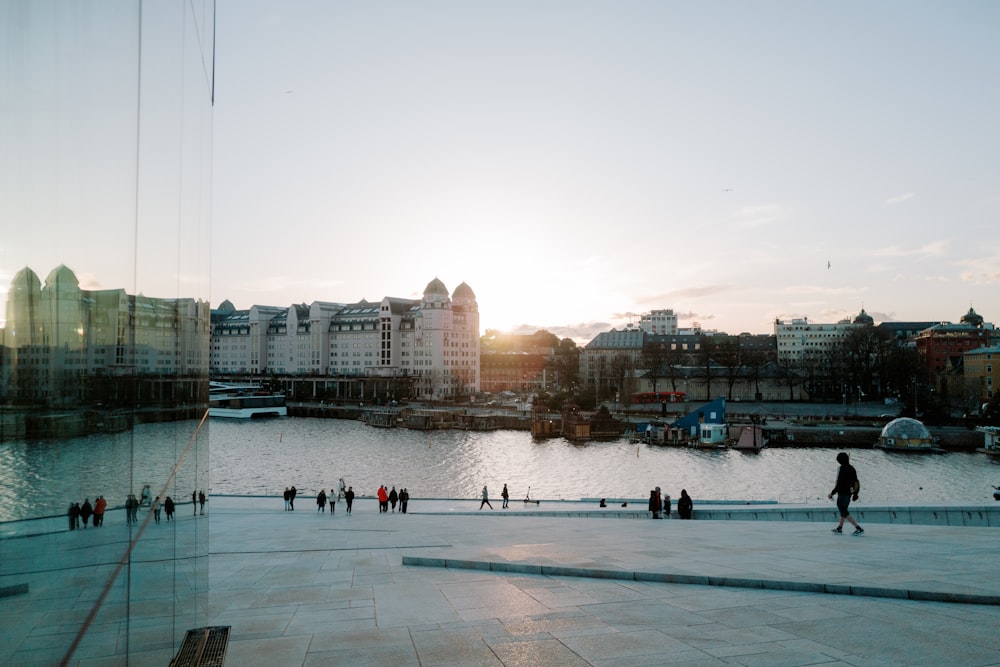 a group of people walking around a large body of water