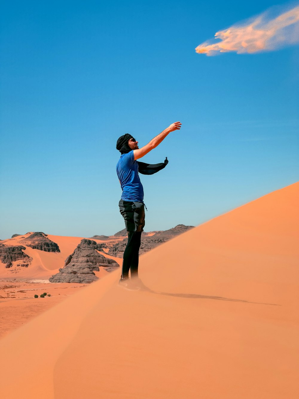 a man flying a kite in the desert