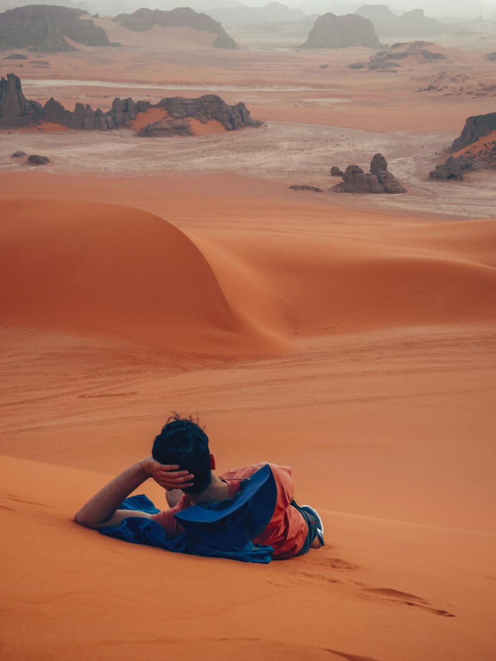 a person sitting in the middle of a desert