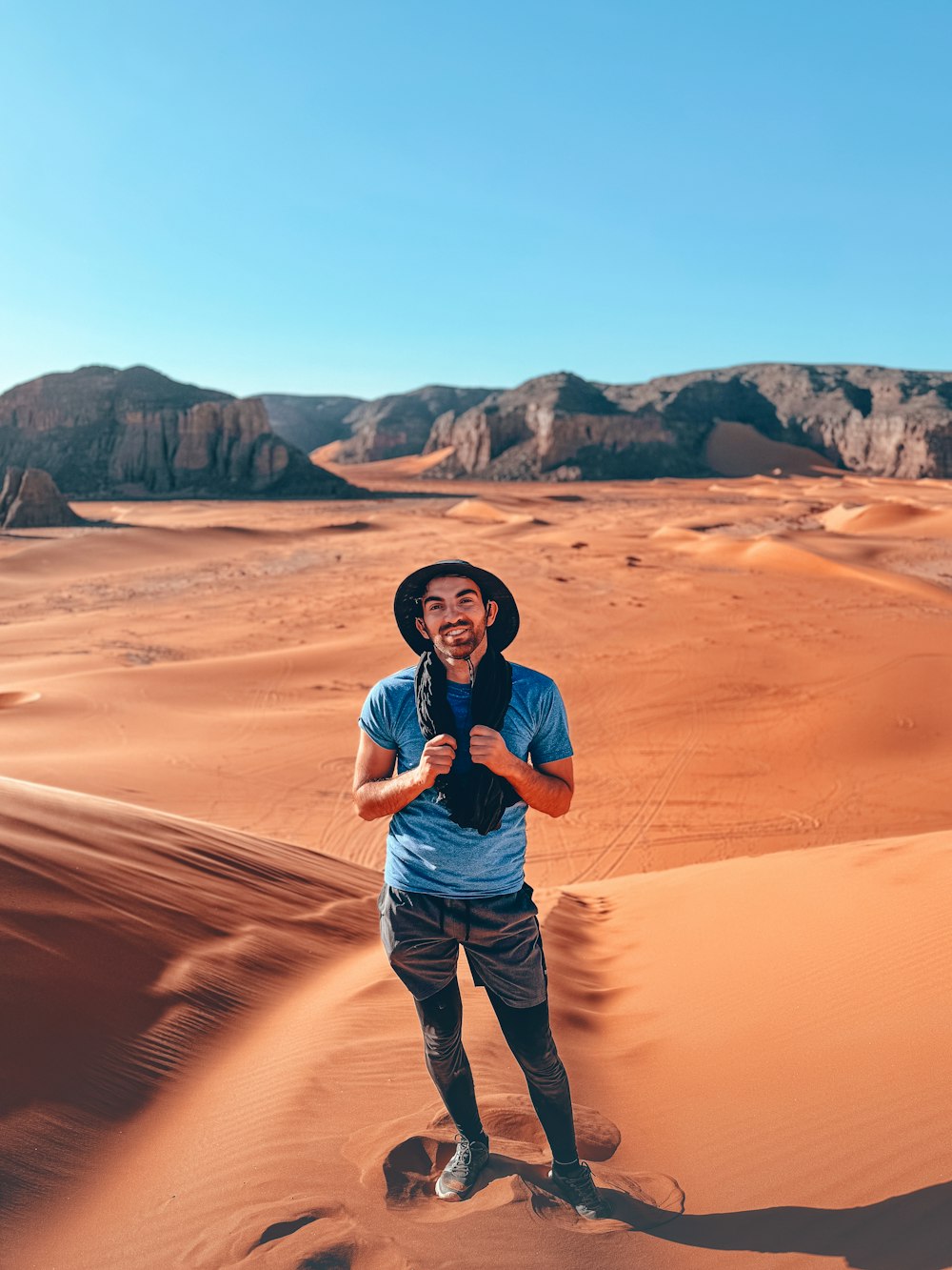 a man standing in the middle of a desert