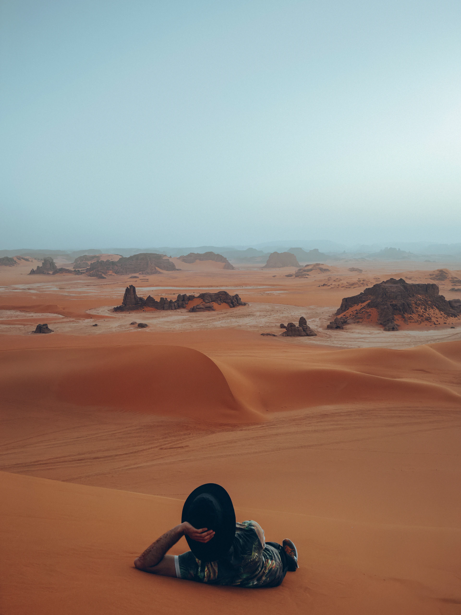 a person laying in the middle of a desert