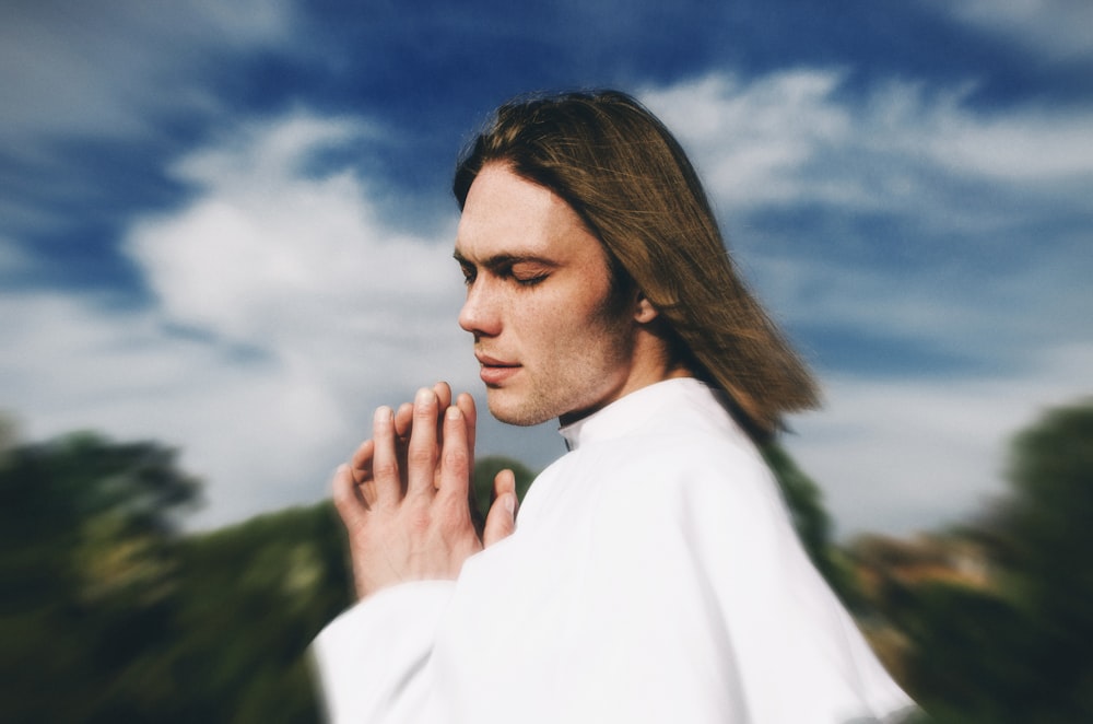 a man with long hair wearing a white robe