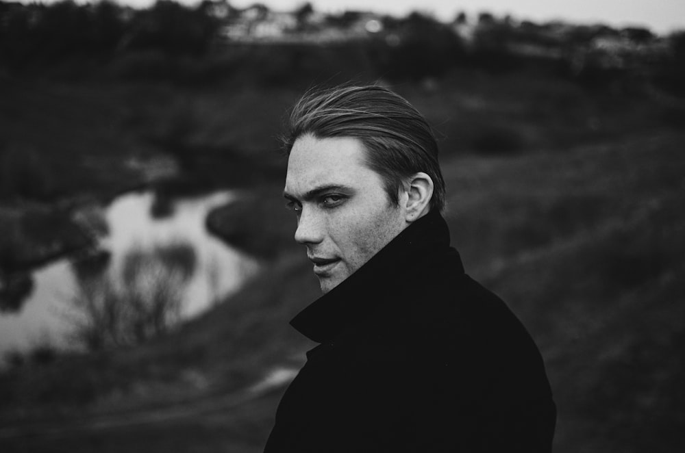 a black and white photo of a man in a black coat