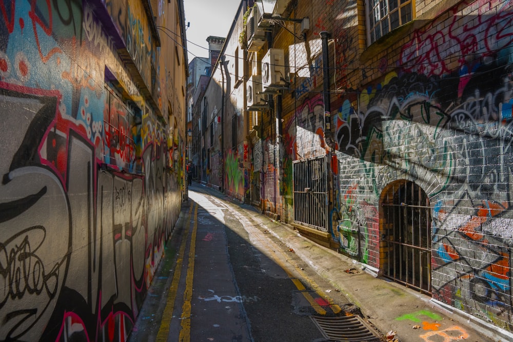 a narrow alley with graffiti all over it