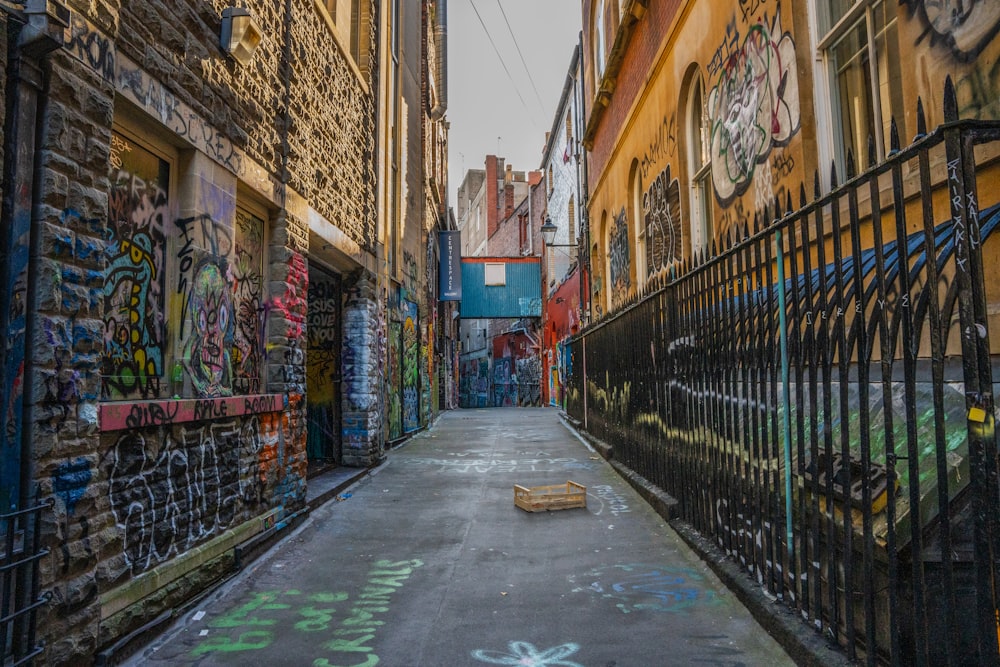 a narrow alley with graffiti on the walls