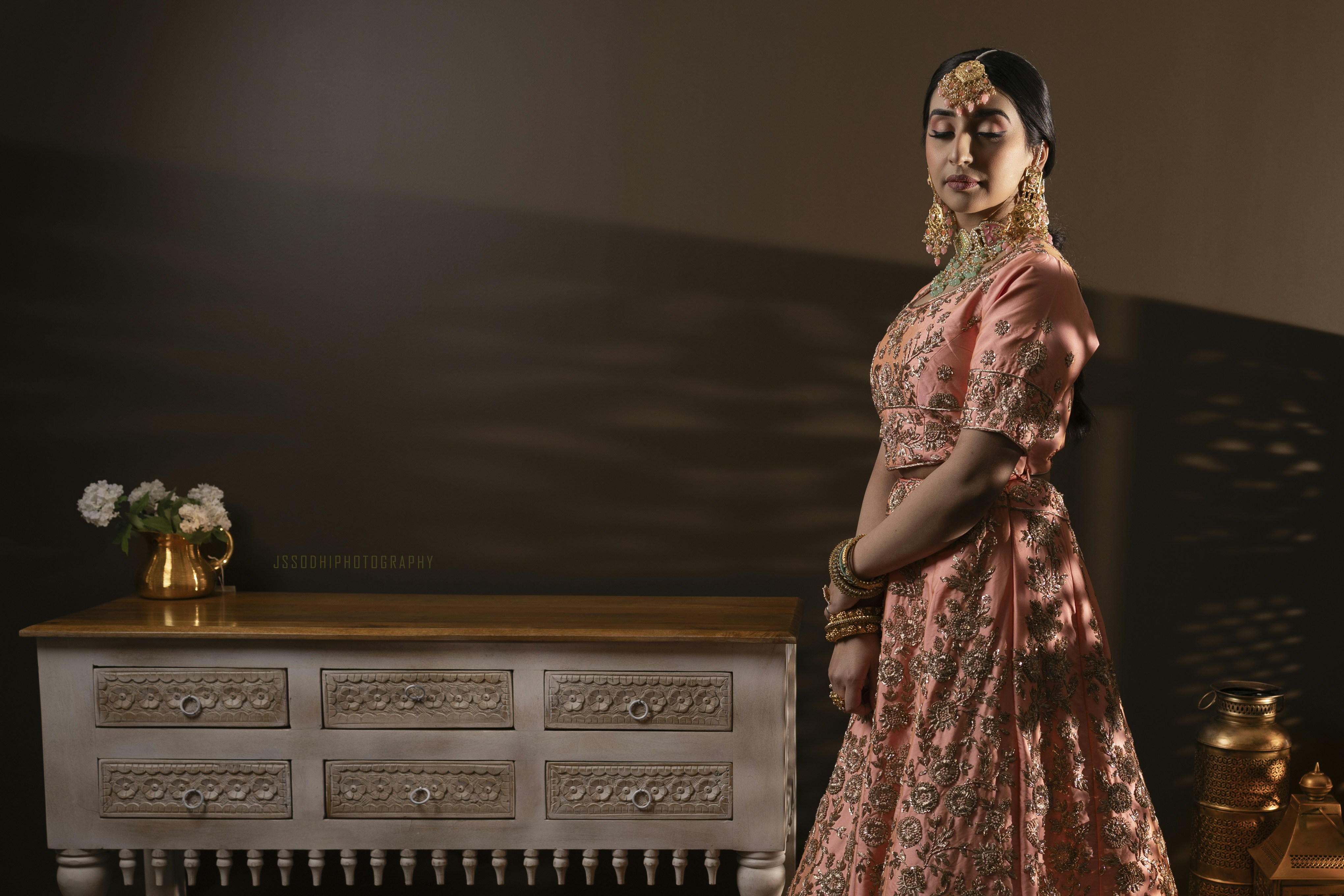 a woman in a dress standing in front of a dresser