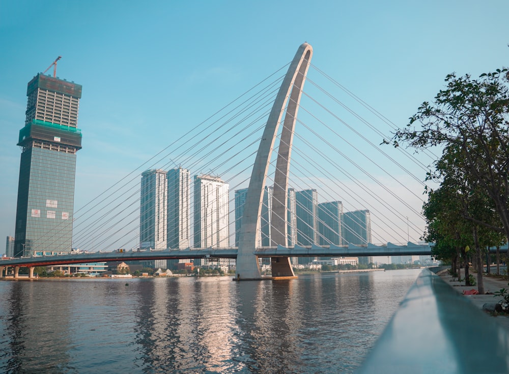 a large bridge over a river with tall buildings in the background