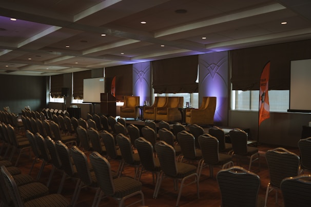 a room filled with lots of chairs and a projector screen