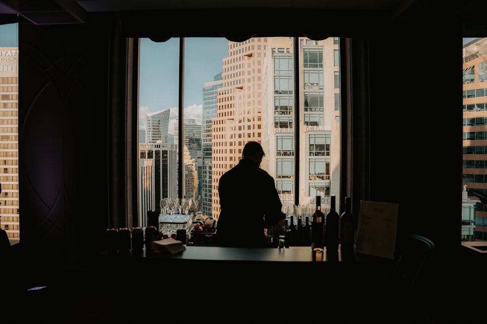 a man standing in front of a window in a dark room