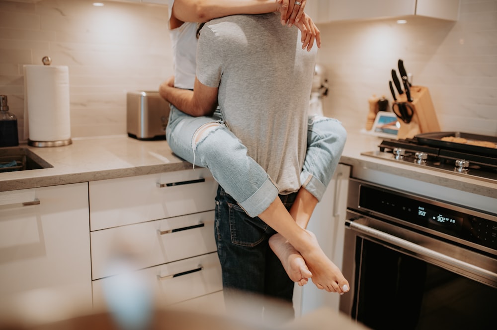 a man holding a woman in a kitchen