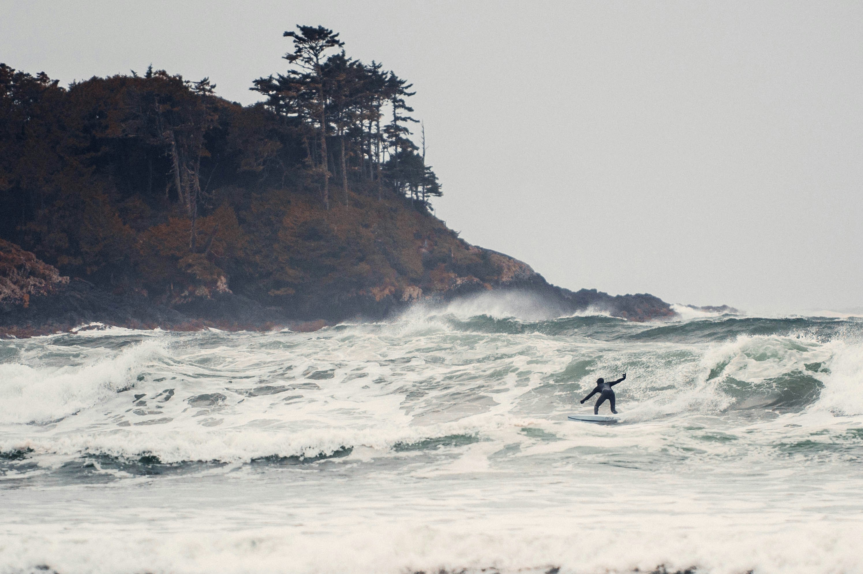 A person riding a surfboard on a wave in the ocean photo – Free Grey ...
