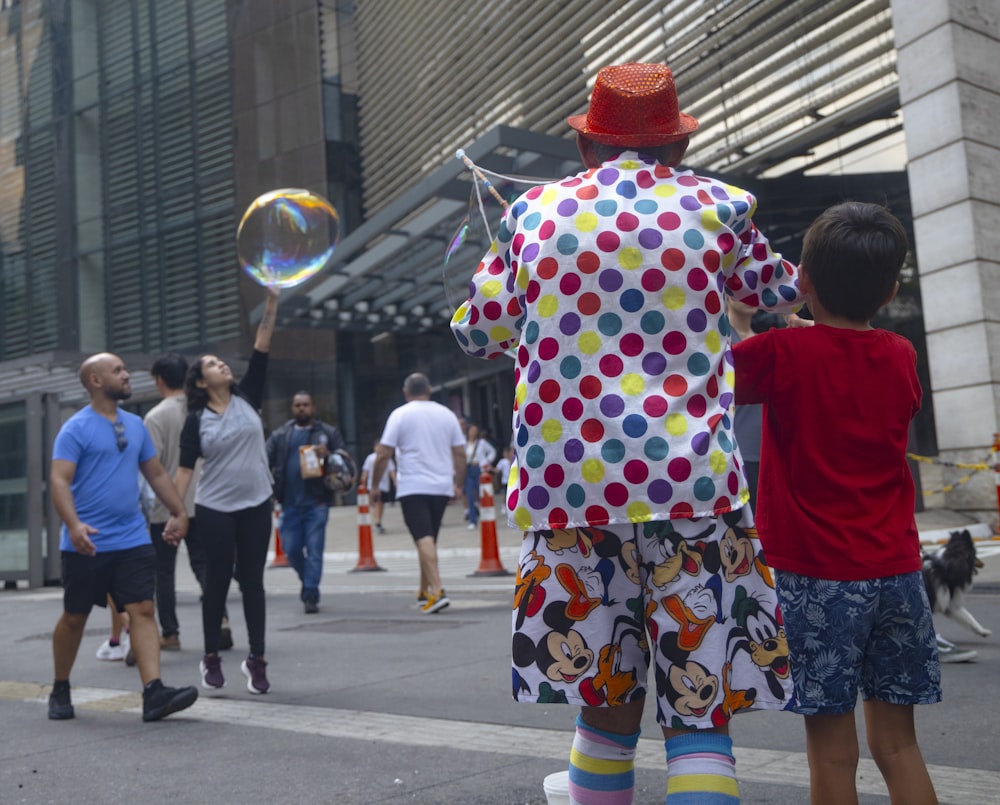 a man in a clown suit and a boy are playing with bubbles