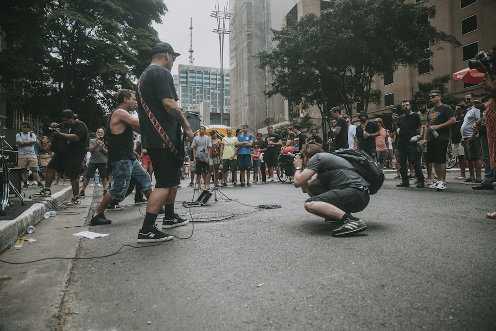 a man kneeling down on the ground in front of a group of people