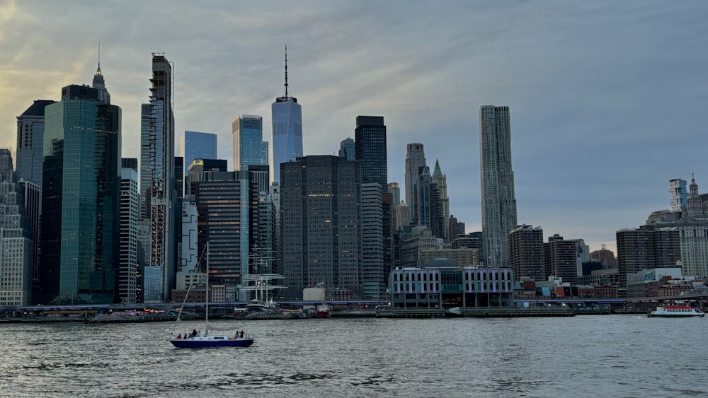 a boat in the water in front of a large city