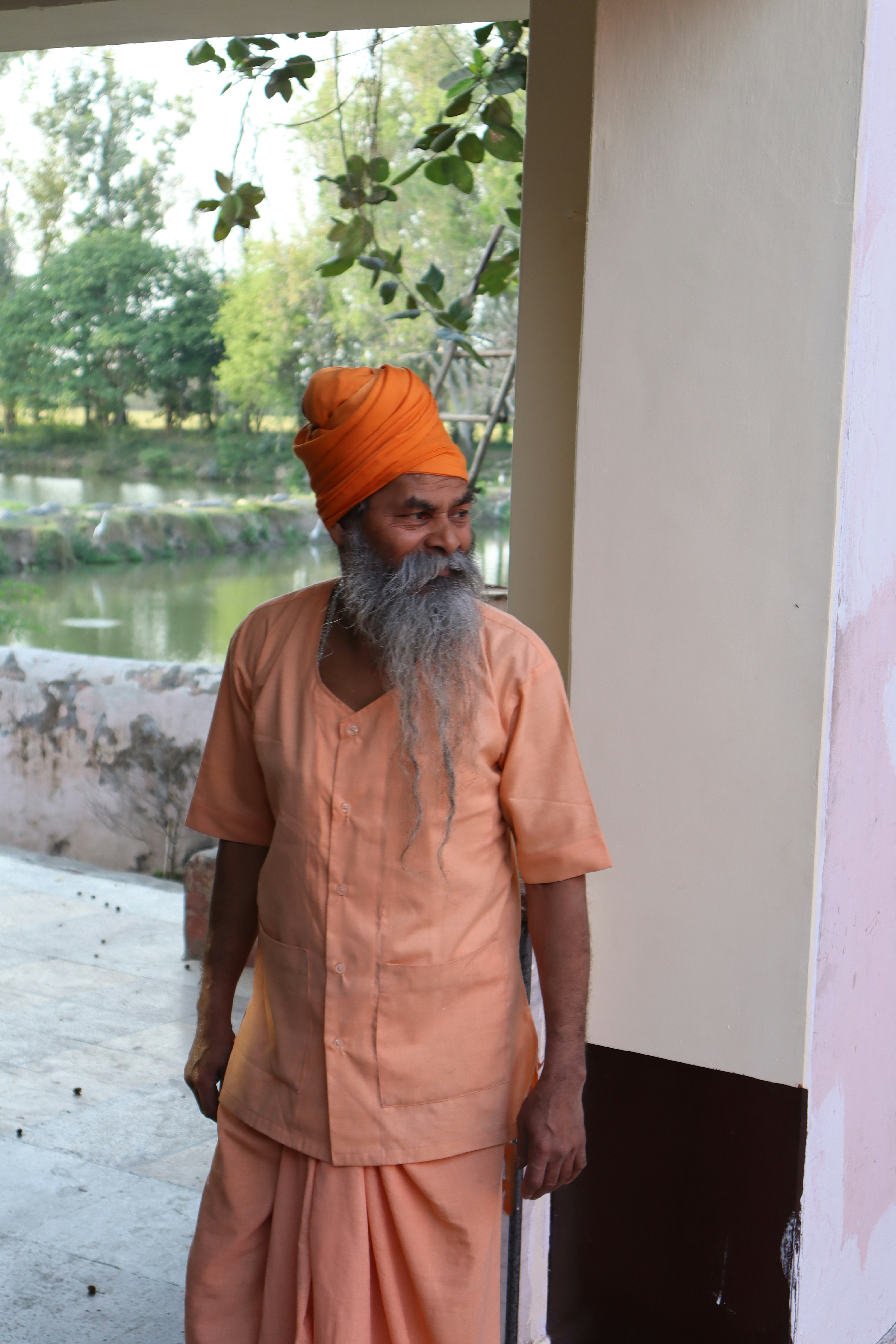 um homem com barba longa e turbante laranja