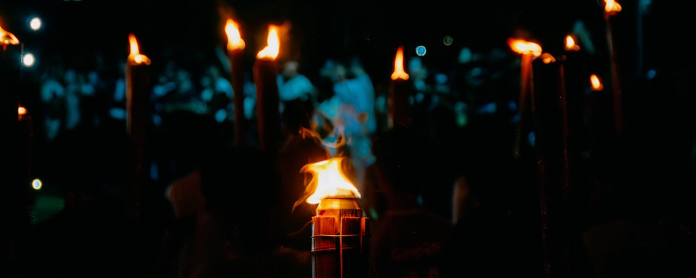 a lit candle in the middle of a dark room