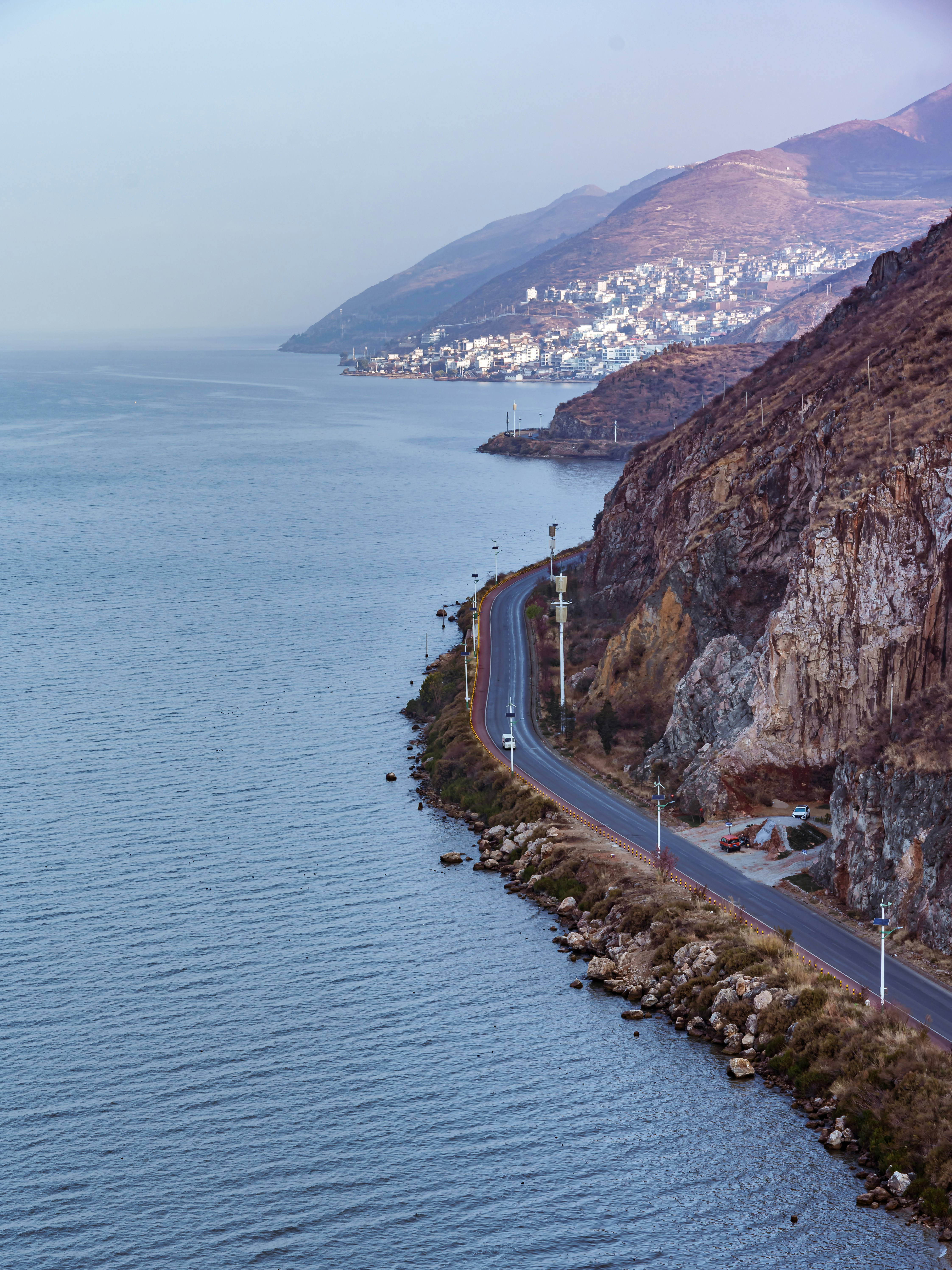 a long stretch of road next to a body of water