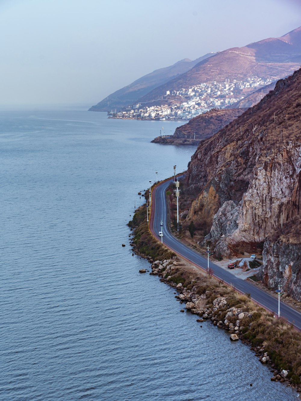 a long stretch of road next to a body of water