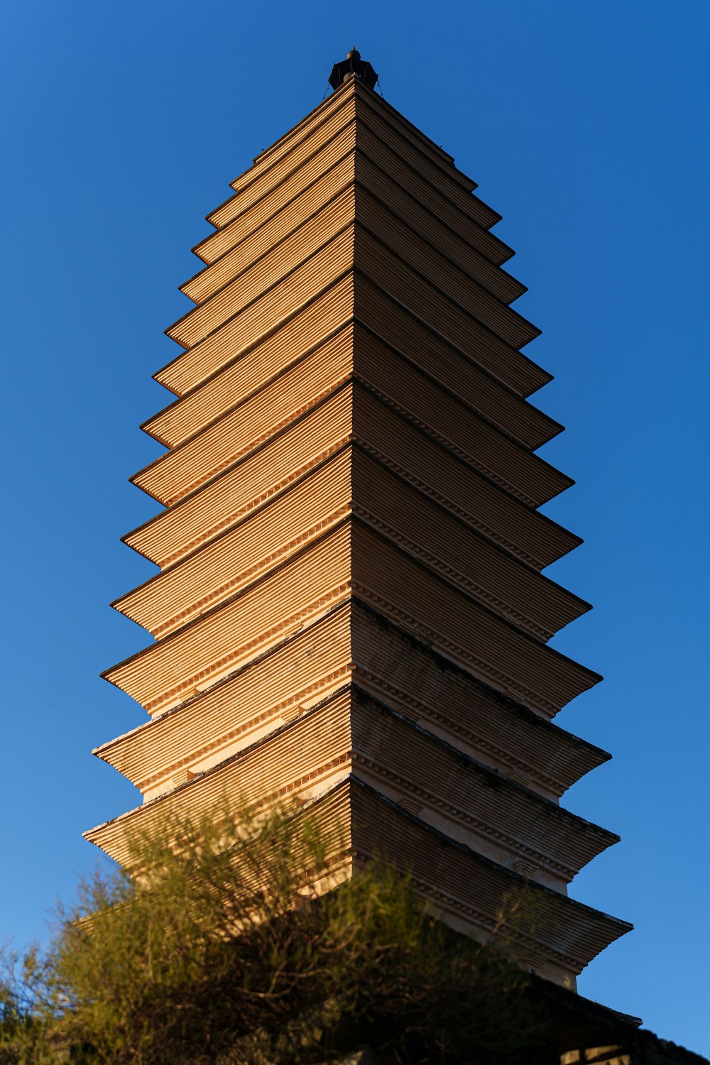 a tall tower with a bird sitting on top of it