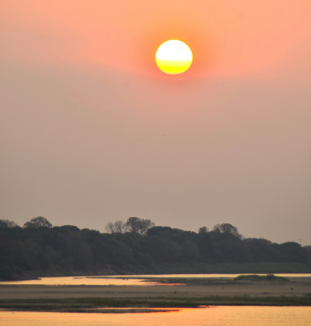 the sun is setting over a body of water