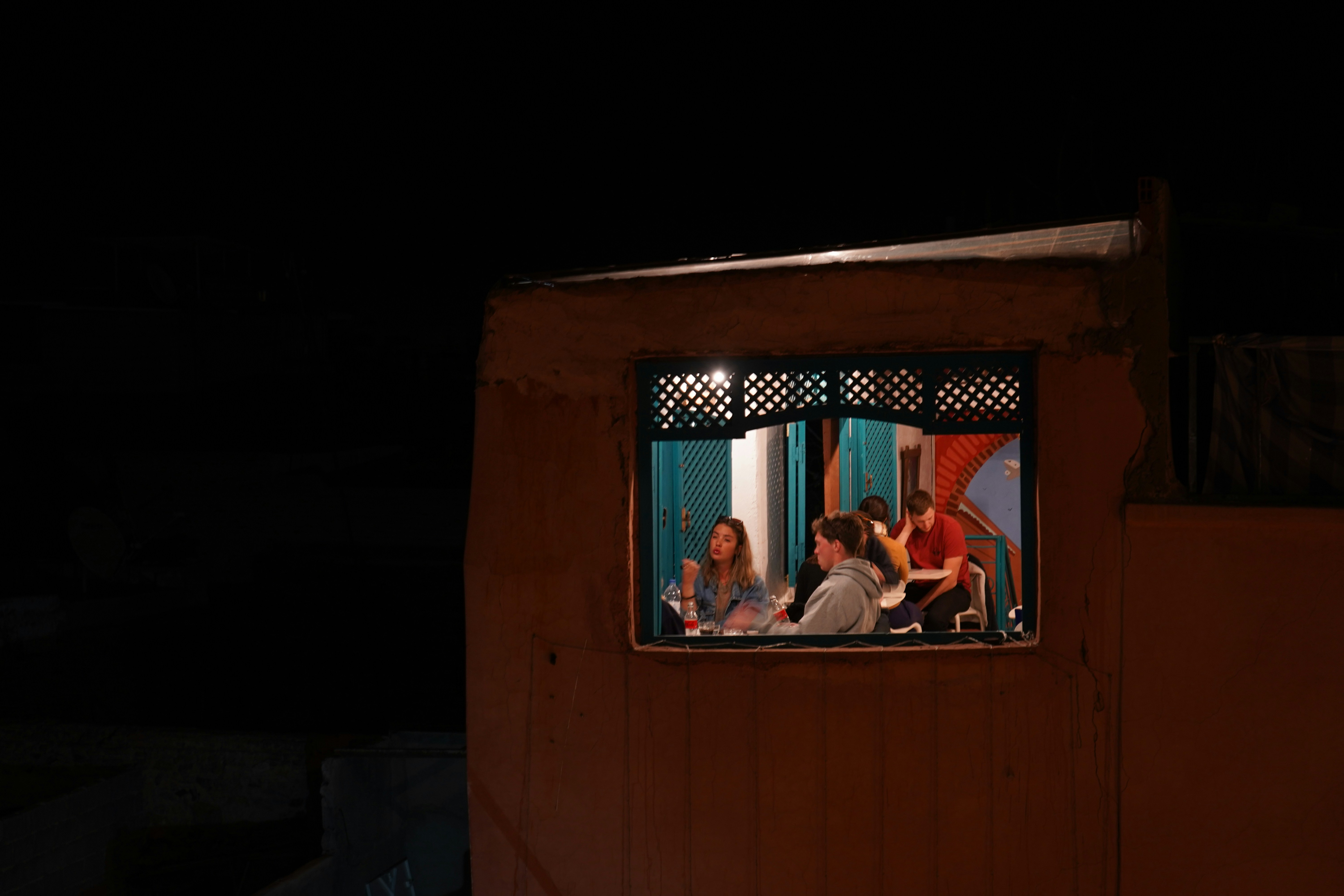 A group of people sitting in a window at night