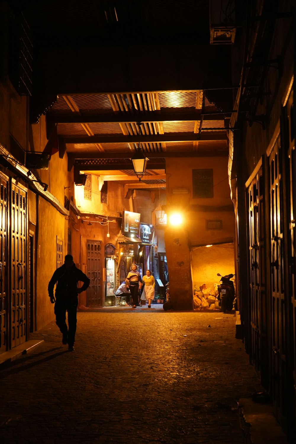 a man walking down a dark alley way at night