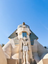a statue of an egyptian god in front of a building