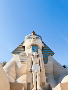 a statue of an egyptian god in front of a building