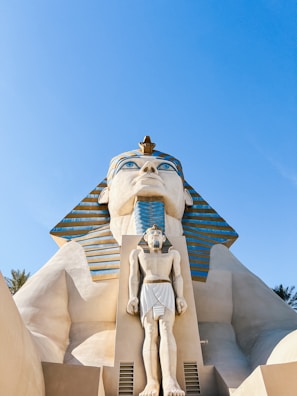 a statue of an egyptian god in front of a building