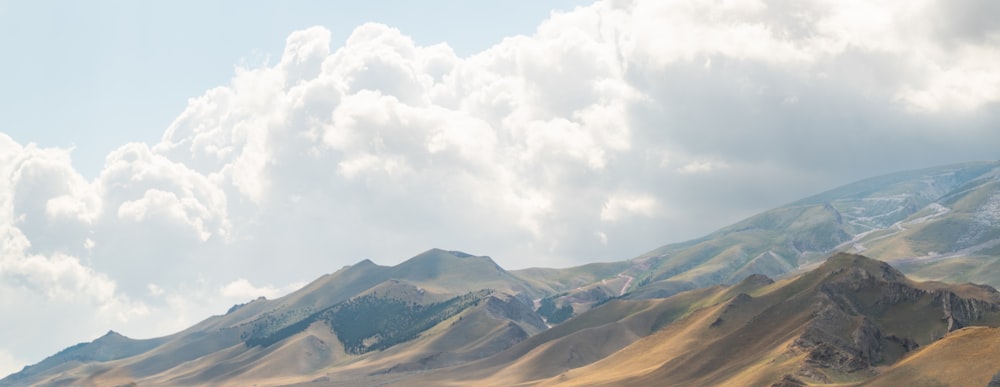 a mountain range with a few clouds in the sky