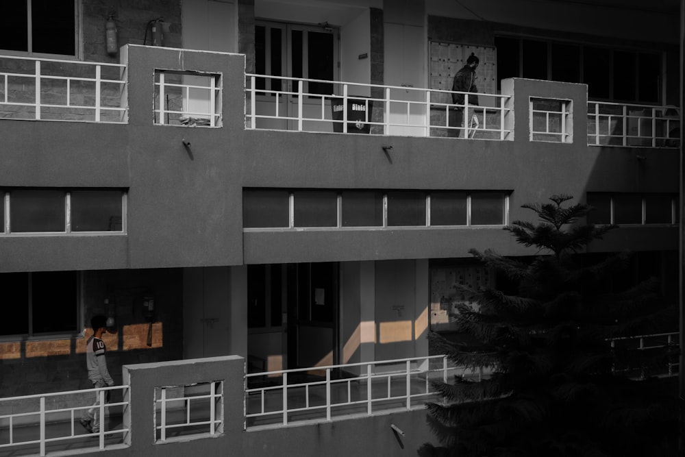 Una foto en blanco y negro de un hombre parado en un balcón