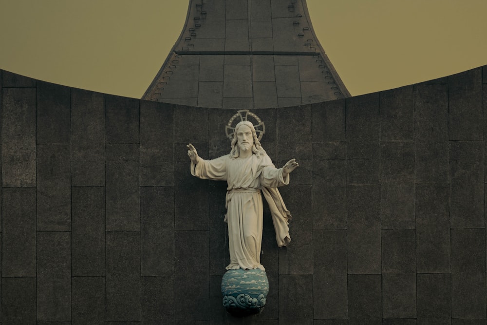 a statue of jesus on the side of a building