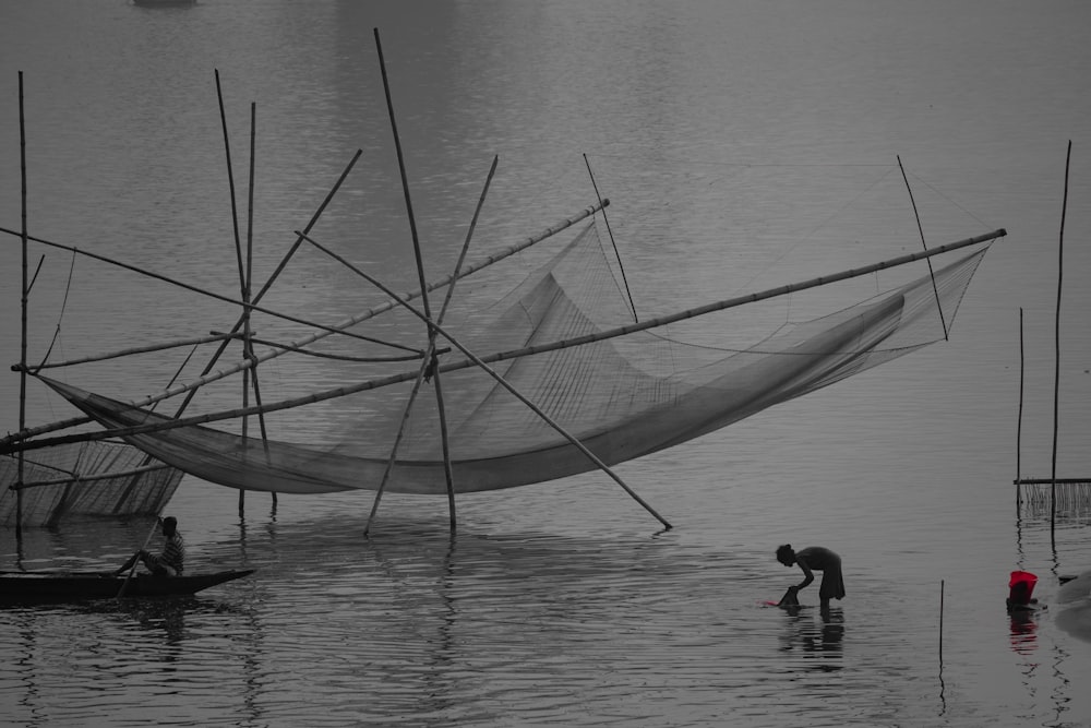 a man standing in a body of water next to a boat