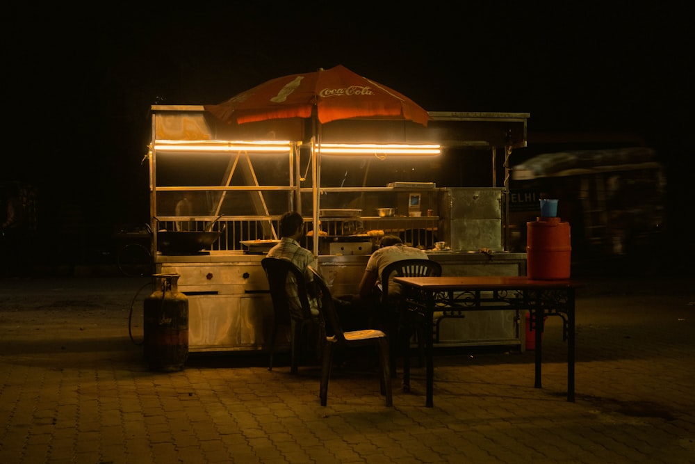 a food cart sitting on the side of a road at night