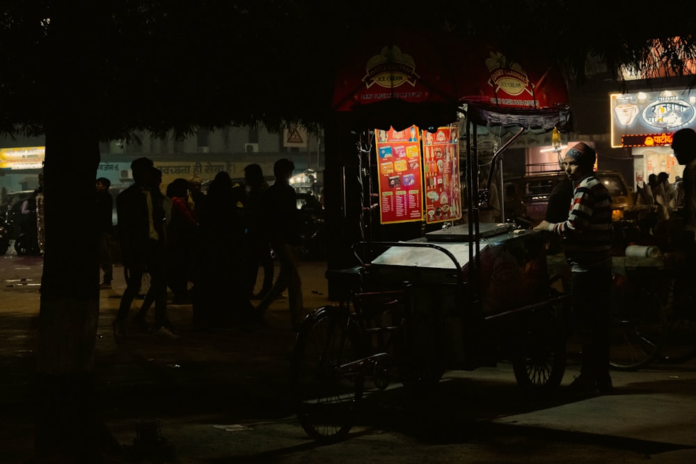a street vendor at night with people walking around
