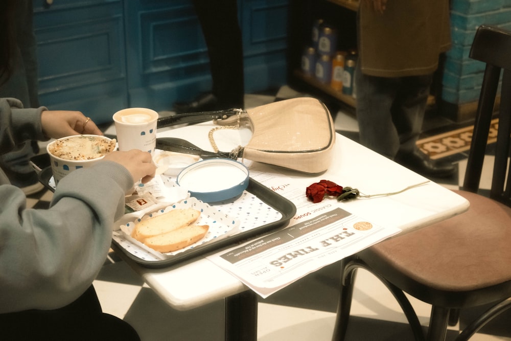 a person sitting at a table with a tray of food