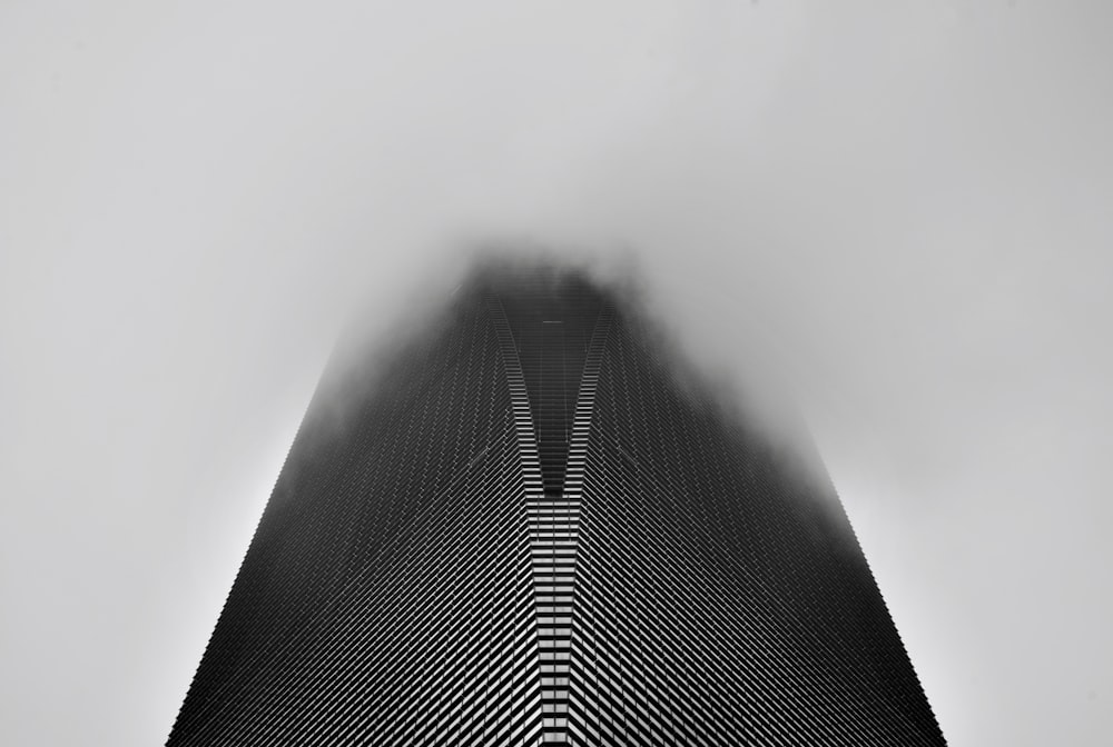 a very tall building in the middle of a foggy sky