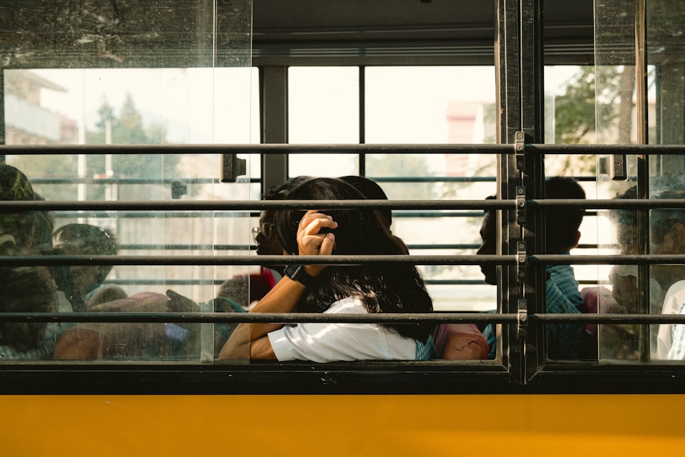 a group of people sitting on a bus looking out the window