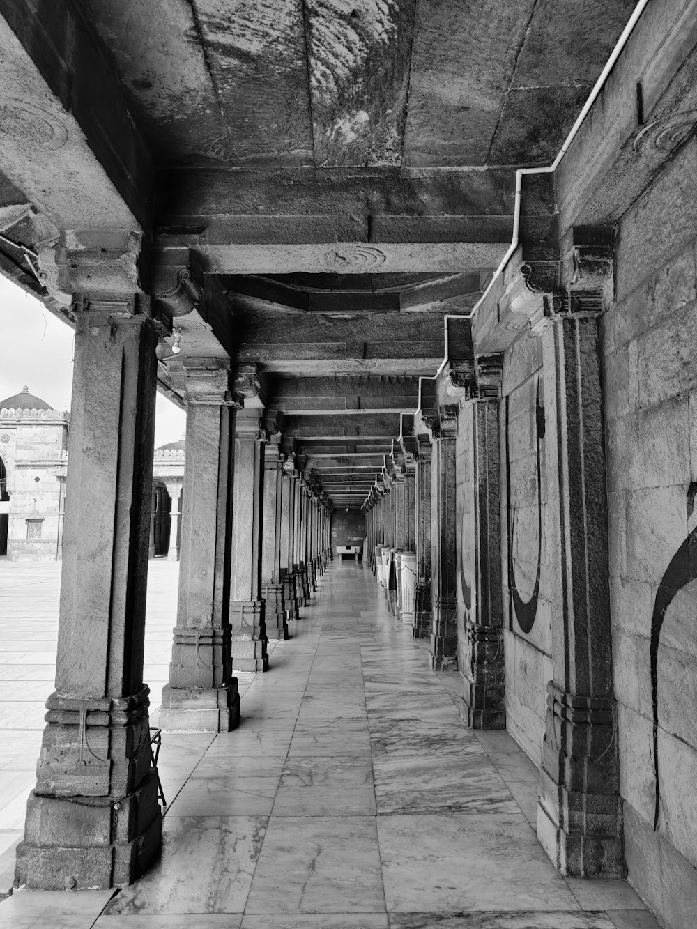 a black and white photo of a long hallway