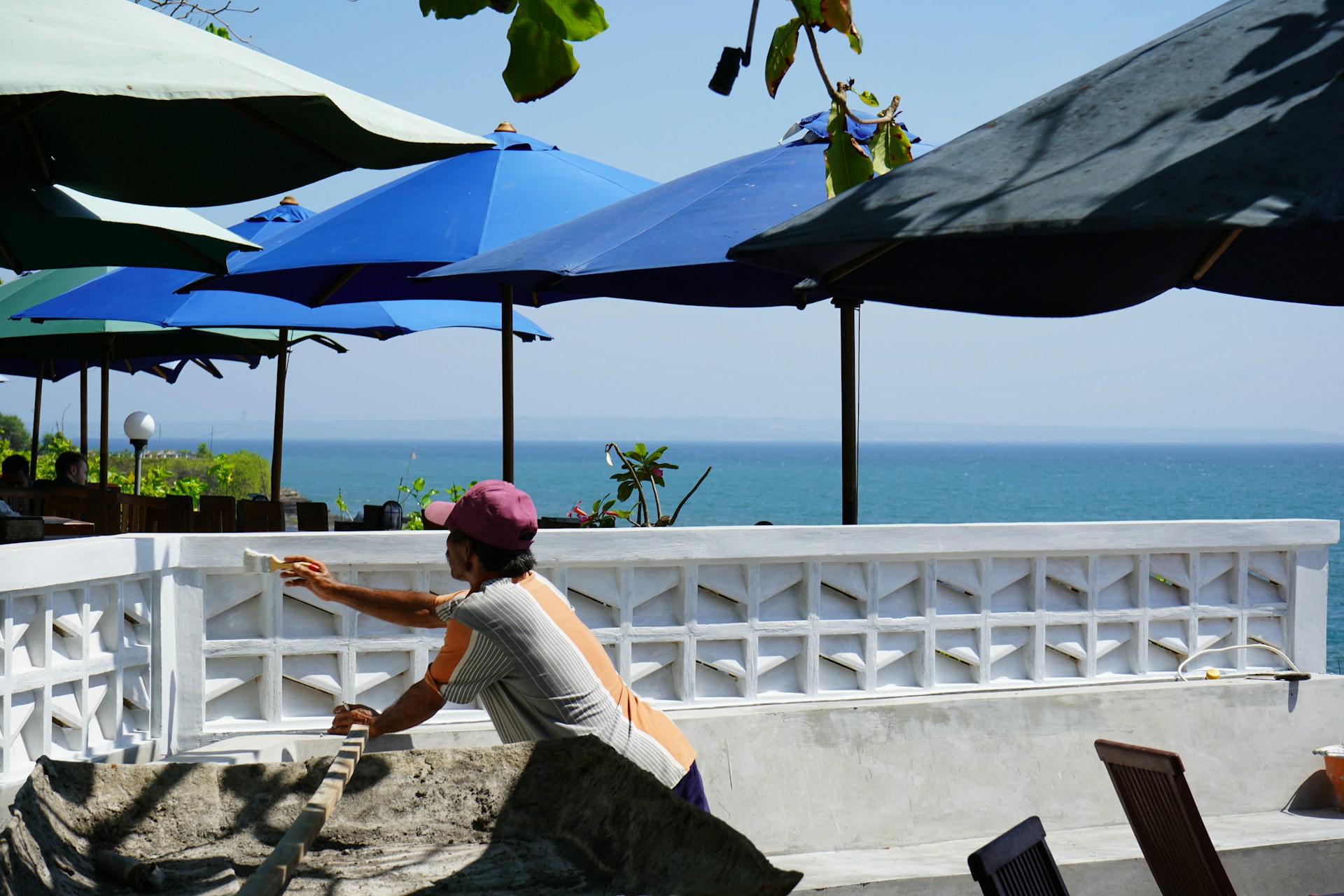 a woman sitting on a ledge near the ocean