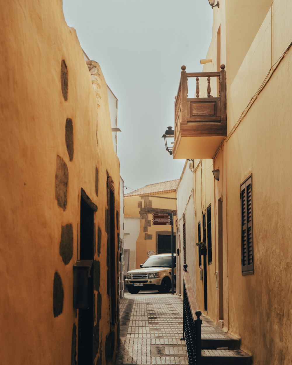 a car is parked on the side of a narrow street